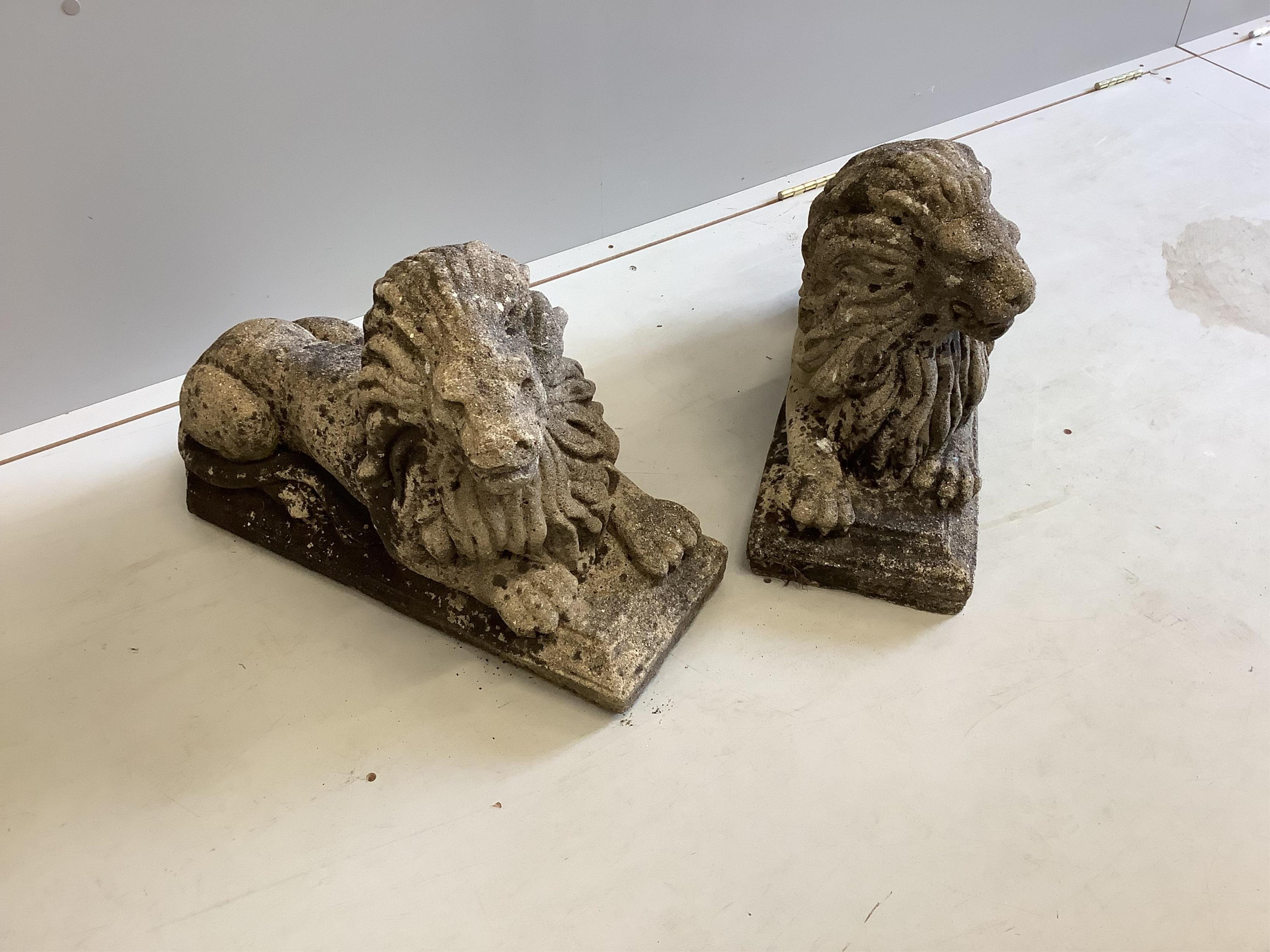 A pair of re-constituted stone recumbent lion garden ornaments, length 58cm, height 38cm. Condition - fair
